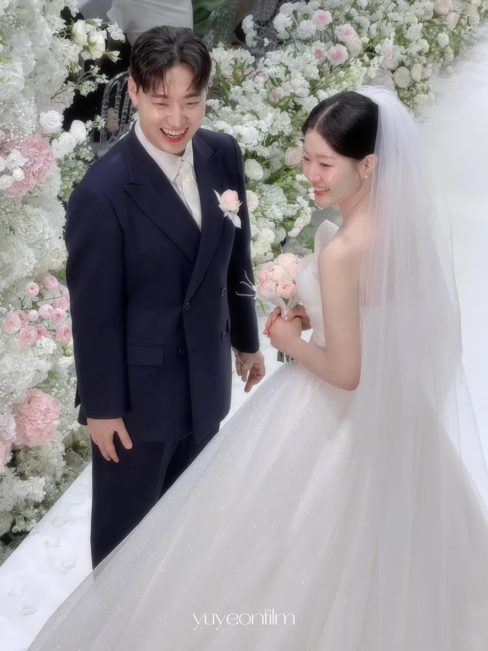 하얀 꽃 앞에서 환하게 웃는 두 사람